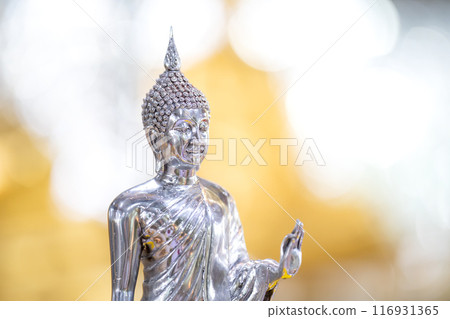 Silver shining Buddha statue with gold and silver background. Silver shining Buddha statue with gold and silver background. 116931365