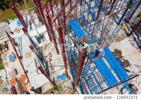 Dual Asian Welder and blacksmith work on the height scaffolding, Shoot from above of them. Dual Asian Welder and blacksmith work on the height scaffolding, Shoot from above of them. 116931371