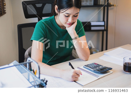 Woman working by using calculator. Woman working by using calculator. 116931463
