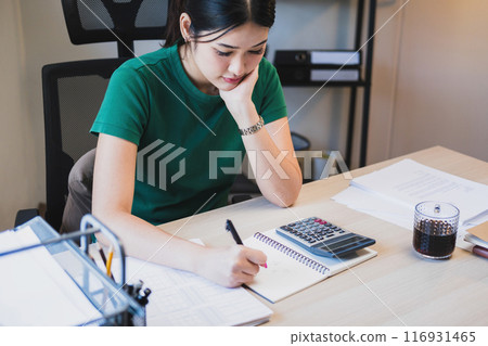 Woman working by using calculator. 116931465