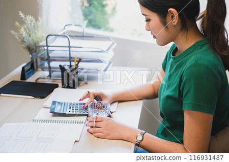 Woman working by using calculator. 116931487