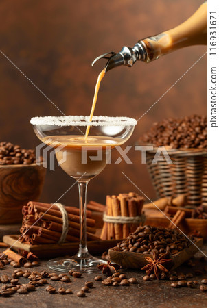 Chocolate martini cocktail or cream liquor is poured from a bottle into a glass. Chocolate martini cocktail or cream liquor is poured from a bottle into a glass. 116931671