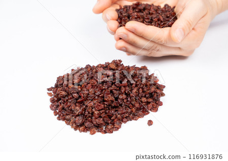 A handful of dried red barberries on a white background. 116931876