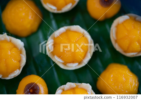 Traditional Golden Thai Dessert; JaMongKut, ThongAek are set on banana leaf. Traditional Golden Thai Dessert; JaMongKut, ThongAek are set on banana leaf. 116932007