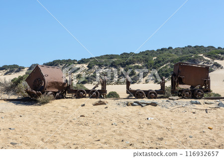 Historic Rusted Mine Carts on Sandy Beach 116932657