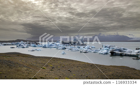 Icebergs floating on jokulsarlon glacier lagoon with storm approaching 116933334