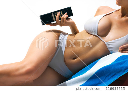 Time for relaxation. Cropped Image for tanned, skin, attractive female body in swimsuit lying on beach towel with vintage wireless phone. 116933335