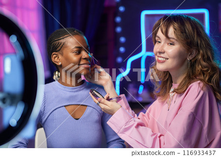 Portrait of smiling young woman recording make up tutorial with ring light doing beauty vlog for social media Portrait of smiling young woman recording make up tutorial with ring light doing beauty vlog for social media 116933437