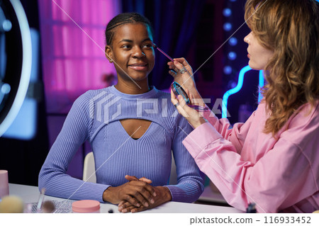 Portrait of two girls doing make up tutorial and recording video with ring light for social media Portrait of two girls doing make up tutorial and recording video with ring light for social media 116933452