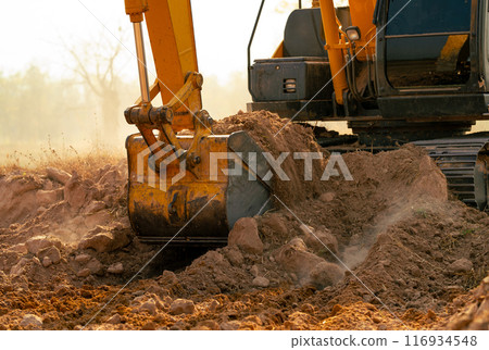 Backhoe working by digging soil at construction site. Crawler excavator digging on demolition site. Excavating machine. Earth moving machine. Excavation vehicle. Construction business. 116934548