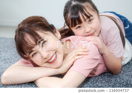 Daughter playing on mom's back Daughter playing on mom's back 116934737