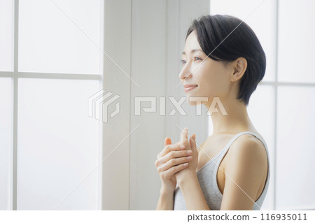 中年婦女在客廳照鏡子 116935011