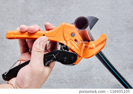 Ratchet type PVC pipe cutter, one hand fast pipes cutting tool on gray background. Ratchet type PVC pipe cutter, one hand fast pipes cutting tool on gray background. 116935105