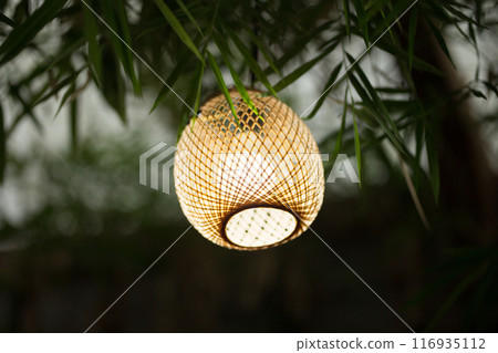 Eco-friendly bamboo lamp illuminates with natural grace. Eco-friendly bamboo lamp illuminates with natural grace. 116935112