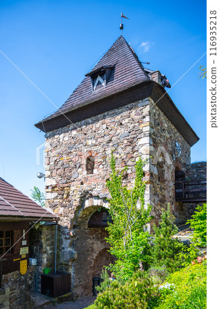 A view of the gate tower at Potstejn Castle Ruins in Czechia, with its stone walls, wooden roof, and a small window. A view of the gate tower at Potstejn Castle Ruins in Czechia, with its stone walls, wooden roof, and a small window. 116935218