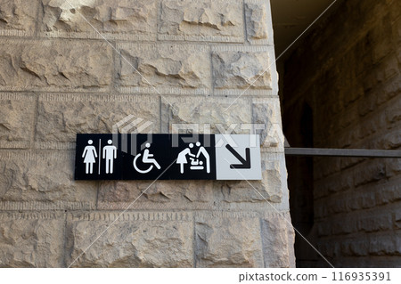 Public toilet sign showing facilities for male, female, baby and wheelchair users on the wall Public toilet sign showing facilities for male, female, baby and wheelchair users on the wall 116935391