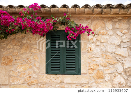 old green window in Mallorca, typical stone house, Spain old green window in Mallorca, typical stone house, Spain 116935407