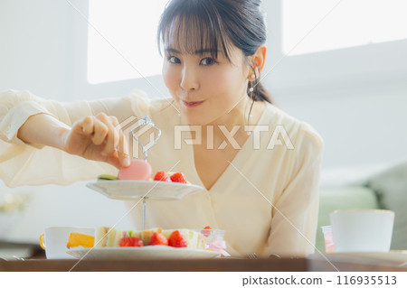 一個女人在咖啡館吃糖果 116935513