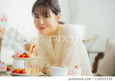 一個女人在咖啡館吃糖果 一個女人在咖啡館吃糖果 116935516