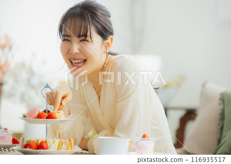 一個女人在咖啡館吃糖果 116935517