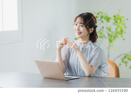 使用一台個人計算機的年輕女子 使用一台個人計算機的年輕女子 116935590