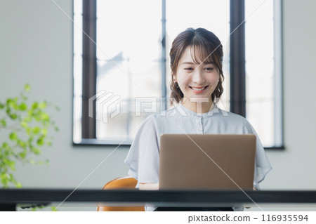 使用一台個人計算機的年輕女子 使用一台個人計算機的年輕女子 116935594