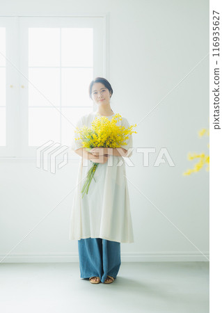 Woman holding a bouquet of mimosa 116935627