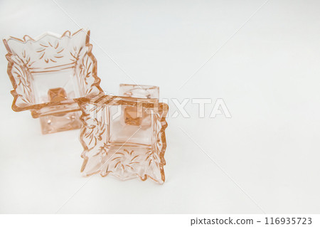 Two empty crystal cremans or vases on a stem for ice cream or salads of peach or orange color lie in close-up on a white background with a place for text. High quality photo Two empty crystal cremans or vases on a stem for ice cream or salads of peach or orange color lie in close-up on a white background with a place for text. High quality photo 116935723