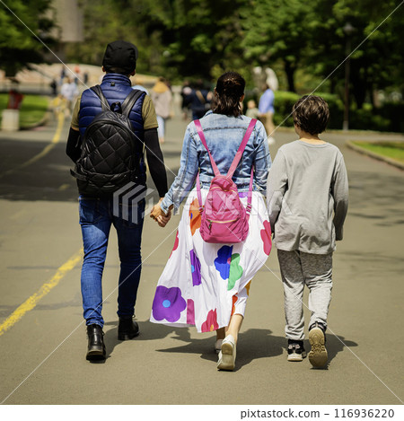 Friendly family, parents and son walk in park, holding hands. Concept of love, joint recreation 116936220