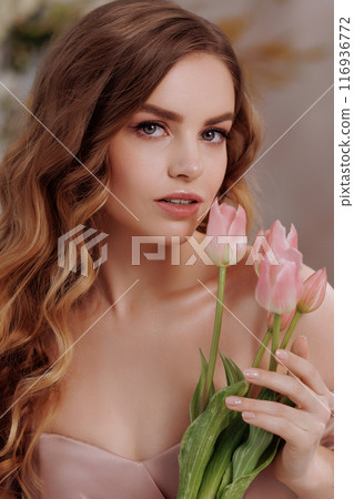 A beautiful woman in a full-length lush pink dress. 116936772