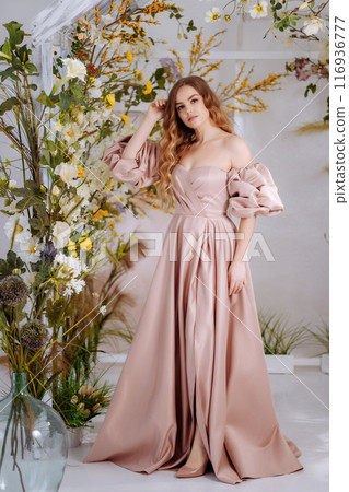 A beautiful woman in a full-length lush pink dress. A beautiful woman in a full-length lush pink dress. 116936777