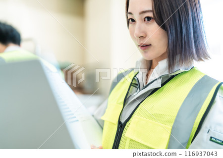 Young female worker managing inventory Young female worker managing inventory 116937043