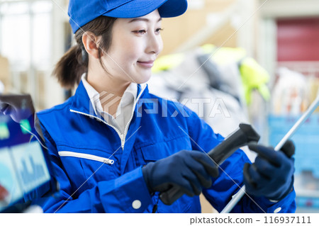 一名女工在配送倉庫工作，一手拿著掃描儀 116937111