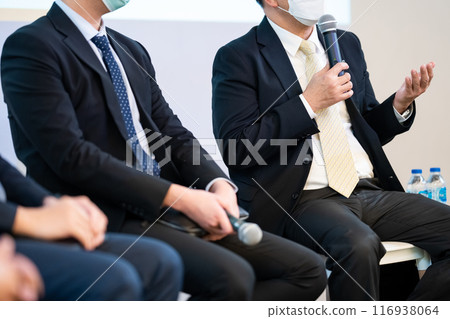 Speaker, who is holding microphone, is discussing how to start business as well as politics, which is difficult topic to find because it is sensitive issue in Thailand. Speaker, who is holding microphone, is discussing how to start business as well as politics, which is difficult topic to find because it is sensitive issue in Thailand. 116938064