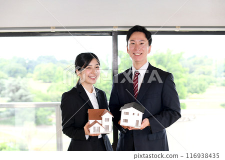 Asian male and female office workers holding house model 116938435