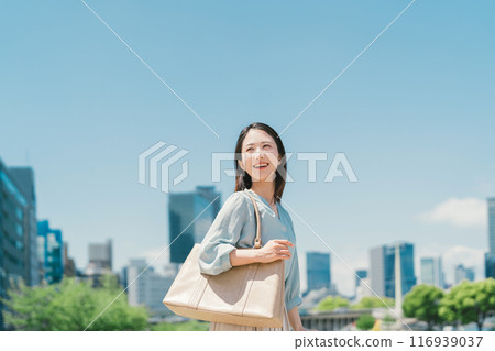 Business woman against the backdrop of the blue sky and buildings Business woman against the backdrop of the blue sky and buildings 116939037