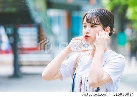 一名年輕女子忍受酷熱,用塑膠瓶為自己降溫 一名年輕女子忍受酷熱,用塑膠瓶為自己降溫 116939084