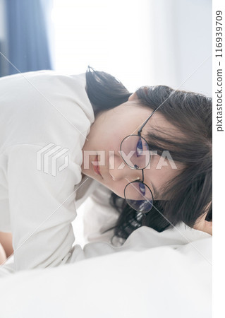 Sexy and cute Japanese, Chinese Thai woman wears white long arm T Shirt on the bed, looks at the camera. 116939709