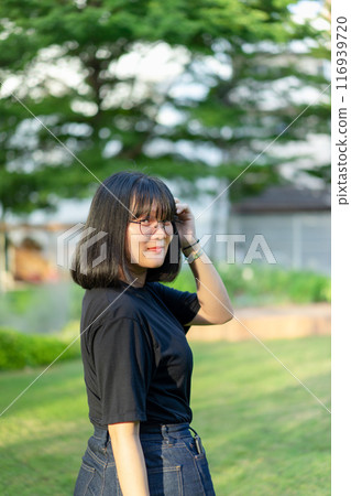 Portrait of the Asian glassese Thai woman is standing in the garden in the morning. 116939720