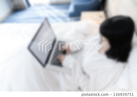 Blur Topview of Glasses Asian cute woman works with laptop white screen on the bed in Work From Home period. 116939731