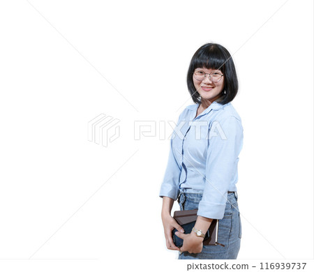 Asian short hair woman wearing eyeglasses smiles sweetly on her face. The blue shirt girl stands quietly, wear her wrist watch and hold a brown notebook. Asian short hair woman wearing eyeglasses smiles sweetly on her face. The blue shirt girl stands quietly, wear her wrist watch and hold a brown notebook. 116939737