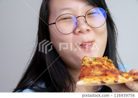 Happy glasses Asian young woman eat Pizza on white background. 116939756