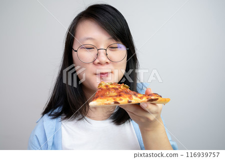 Happy glasses Asian young woman eat Pizza on white background. 116939757