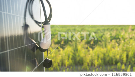 Close up of electric car charging plug with solar panel 116939861