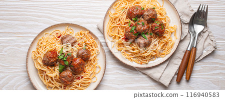 Two plates of delicious spaghetti with meatballs served on white wooden table top view Two plates of delicious spaghetti with meatballs served on white wooden table top view 116940583