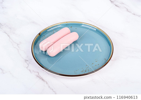 Boiled sausages on a blue plate with reflection. 116940613