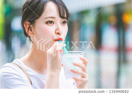 Young woman drinking water outdoors Young woman drinking water outdoors 116940682