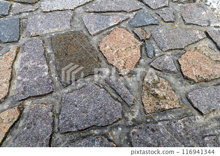 Background cobblestone road close-up. Stone pavement. Background cobblestone road close-up. Stone pavement. 116941344