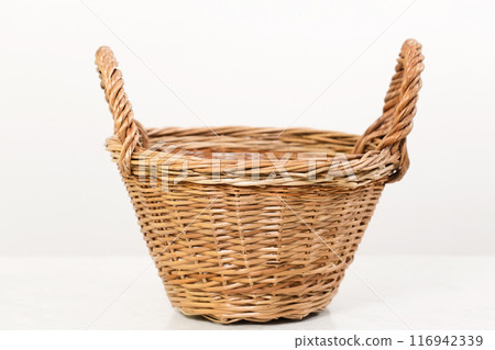 Empty wicker basket with two handles, low angle shot 116942339