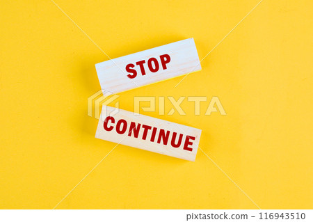Conceptual symbol. Copy space. Stop or continue words written a conceptual phrase on the wooden blocks, top view Conceptual symbol. Copy space. Stop or continue words written a conceptual phrase on the wooden blocks, top view 116943510